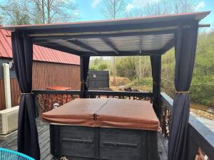 een zwarte pergola met een matras op een dek bij Lazy Bear Retreat by the Creek in Pickens