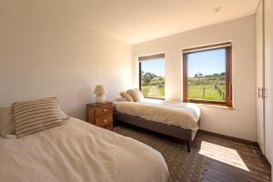 um quarto com 2 camas e uma janela em Maravillosa Casa en Granja Sustentable em Puerto Varas