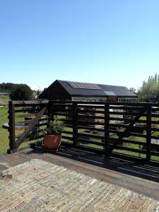 uma cerca de madeira com uma planta à frente em Maravillosa Casa en Granja Sustentable em Puerto Varas