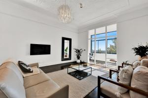- un salon avec un canapé et une table dans l'établissement Paris End of St Kilda Apartment, à Melbourne