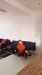 Chott MeriemにあるKalthoumのベッド2台、テーブル、椅子が備わる客室です。