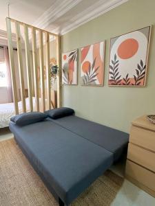 een bed in een kamer met schilderijen aan de muur bij Studio avec Terrasse au Cœur de l'Agdal in Rabat