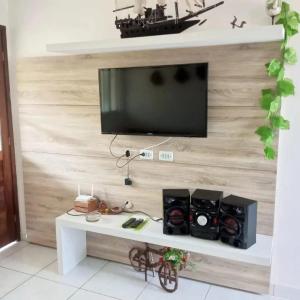 a living room with a tv on a wall at Residencial Jardins Ilha de Itamaracá in Vila Velha