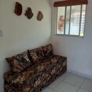 a brown couch in a room with a window at Residencial Jardins Ilha de Itamaracá in Vila Velha