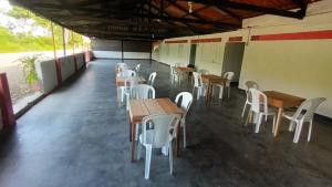 eine Gruppe von Tischen und Stühlen in einem Zimmer in der Unterkunft Encanto Natural in Villagarzón