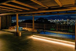 Okayama International Hotel في أوكاياما: مسبح على السطح مطل على المدينة ليلا