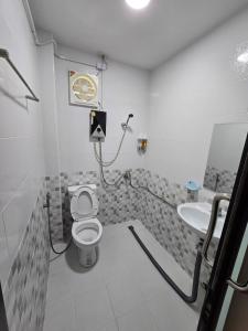 een badkamer met een toilet en een wastafel bij ปีกุนรีสอร์ท & Swimming pool (Pigoon Resort) 