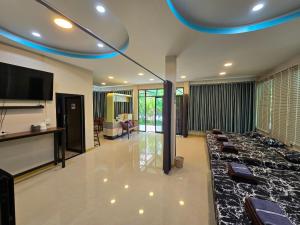 een woonkamer met een flatscreen-tv en een bank bij ปีกุนรีสอร์ท & Swimming pool (Pigoon Resort) 
