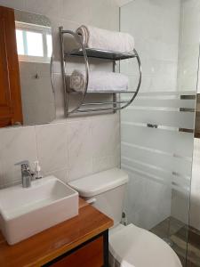 uma casa de banho com um lavatório, um WC e um espelho. em KC Hotel & Suites em Comitán de Domínguez
