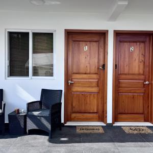 duas portas de madeira numa casa com uma cadeira em KC Hotel & Suites em Comitán de Domínguez