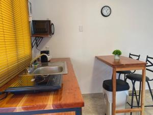 uma cozinha com um lavatório e um balcão com uma mesa em KC Hotel & Suites em Comitán de Domínguez