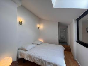 ein kleines Schlafzimmer mit einem weißen Bett und einem Fenster in der Unterkunft Appartement Saint-Jean-de-Luz, 2 pièces, 4 personnes - FR-1-239-974 in Saint-Jean-de-Luz