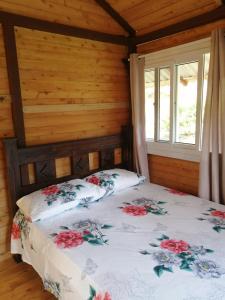 Un dormitorio con una cama con flores. en Mario's Lodge Providencia, en Copey