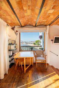 mesa y sillas en una habitación con ventana en Apartment with Terrace Views of BCN en Barcelona
