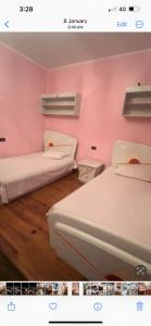 - 2 lits dans une chambre aux murs roses dans l'établissement ابراج عثمان اغاخان كورنيش النيل, au Caire