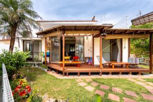 a house with a wooden deck and a patio at Beach House Yomitan in Yomitan