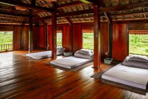 um quarto com 4 camas num piso de madeira em Nhà Của Bin - Bin's House (Xóm Bin, xã Pù Bin, huyện Mai Châu, Hòa Bình) em Mai Châu