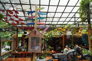 a store with colorful paper airplanes hanging from the ceiling at SECRET GARDEN CAT BA in Cat Ba