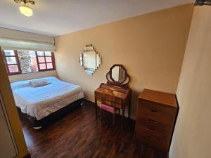 a bedroom with a bed and a mirror and a dresser at Garden House Miraflores in Lima