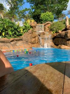 une piscine avec une cascade et une piscine dans l'établissement Hotel Fazenda Tucano, à Capim Branco
