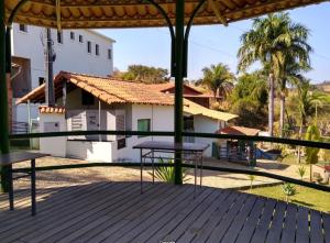 une terrasse avec une table et une maison dans l'établissement Hotel Fazenda Tucano, à Capim Branco