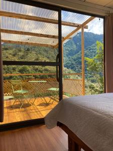 a bedroom with a large window with a view of the mountains at Mario's Lodge Providencia in El Copey
