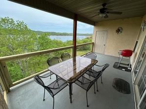 patio con mesa y sillas en el balcón en Lakefront Indian Point Condo with Boat Slip, en Branson