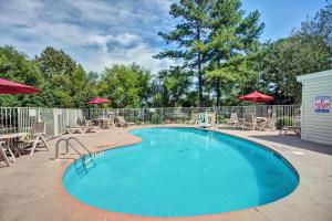 uma piscina com cadeiras e guarda-sóis em Travelodge by Wyndham Fayetteville em Fayetteville