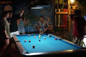 a group of people standing around a pool table at SECRET GARDEN CAT BA in Cat Ba