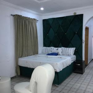 a bedroom with a large bed with a green headboard at BLUE MOON HOTELS VICTORIA ISLAND in Lagos