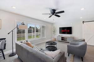 a living room with a couch and a tv at Pegasus - Modern Tempe Getaway with Pool & Game Room in Tempe