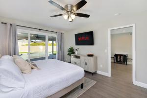 a bedroom with a white bed and a ceiling fan at Pegasus - Modern Tempe Getaway with Pool & Game Room in Tempe +39 photos