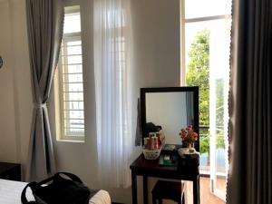 藩郎的住宿－Nam Dương 2 Hotel，一间带镜子和一张带镜子的桌子的卧室