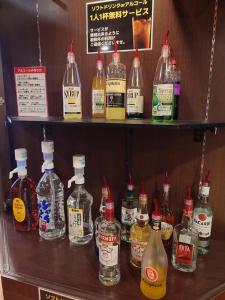 a display of bottles of alcohol on a shelf at ホテル カーシュ Cache 男塾ホテルグループ in Himeji