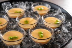 a group of small glasses of orange pudding with green grapes at HOTEL MYSTAYS Miyazaki in Miyazaki