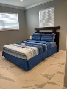 um quarto com uma cama grande e lençóis azuis em WONDERFULL NORTH MIAMI em Miami