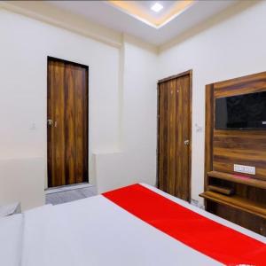 Schlafzimmer mit einem Bett und einem Flachbild-TV in der Unterkunft Hotel King View in Ahmedabad