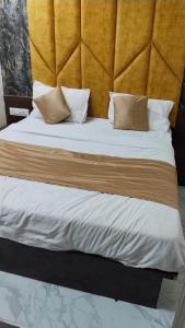 ein Bett mit weißer Bettwäsche und Kissen darauf in der Unterkunft Hotel King View in Ahmedabad
