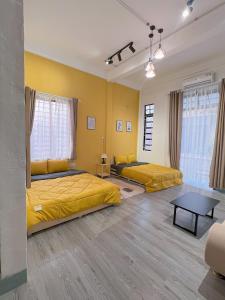 2 Betten in einem Zimmer mit gelben Wänden in der Unterkunft Neko Homestay Hue in Hue