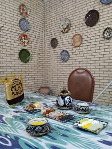 une table avec des assiettes de nourriture au-dessus dans l'établissement Guest House "AN" & Teahouse, à Boukhara