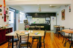 una cucina e una sala da pranzo con tavoli e sedie in legno di Net House Cusco a Cuzco