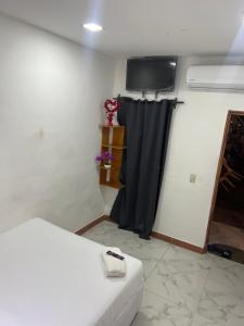 Habitación con cama y cortina negra en RANCHO MAMA JUANY en El Cuco