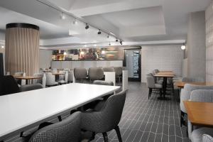 SpringHill Suites by Marriott New York Manhattan Times Square في نيويورك: مطعم بطاولة بيضاء وكراسي