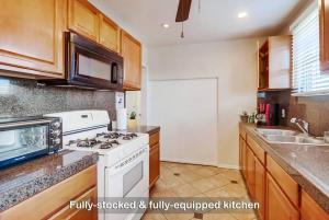 a kitchen with a white stove and a sink at Entire Private 3-Bedroom Home with Baby Crib, Wi-Fi & Laundry in San Diego