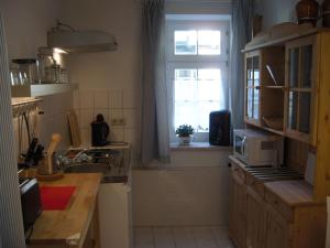 eine kleine Küche mit einem Waschbecken und einem Fenster in der Unterkunft Ferienwohnungen Zur Kaiserstrasse in Quedlinburg