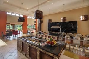 a kitchen with a buffet of food on a table at Protea Hotel by Marriott Chipata in Chipata