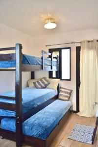 a bedroom with two bunk beds with blue sheets at Casa Sol Luna Barrios Coloniales, Antigua Guatemala in San Pedro Las Huertas