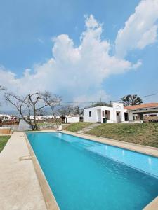 duży niebieski basen przed domem w obiekcie Casa Sol Luna Barrios Coloniales, Antigua Guatemala w mieście San Pedro Las Huertas