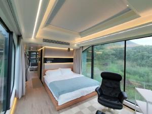 um quarto com uma cama, uma cadeira e uma janela em SPACE-VESSEL Base - Vacation STAY 42244v em Yufu