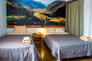 two beds in a room with a painting on the wall at Net House Cusco in Cusco